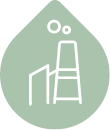 Icon of an industrial plant inside a green oil drop, representing lubricants for industrial applications.