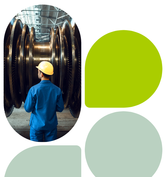 Worker in blue uniform and yellow hard hat inspecting turbine blades in a factory, with abstract green and grey geometric design elements.